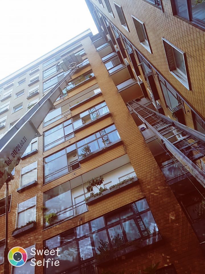 Alto palazzo in mattoni ripreso dal basso contro un cielo luminoso.