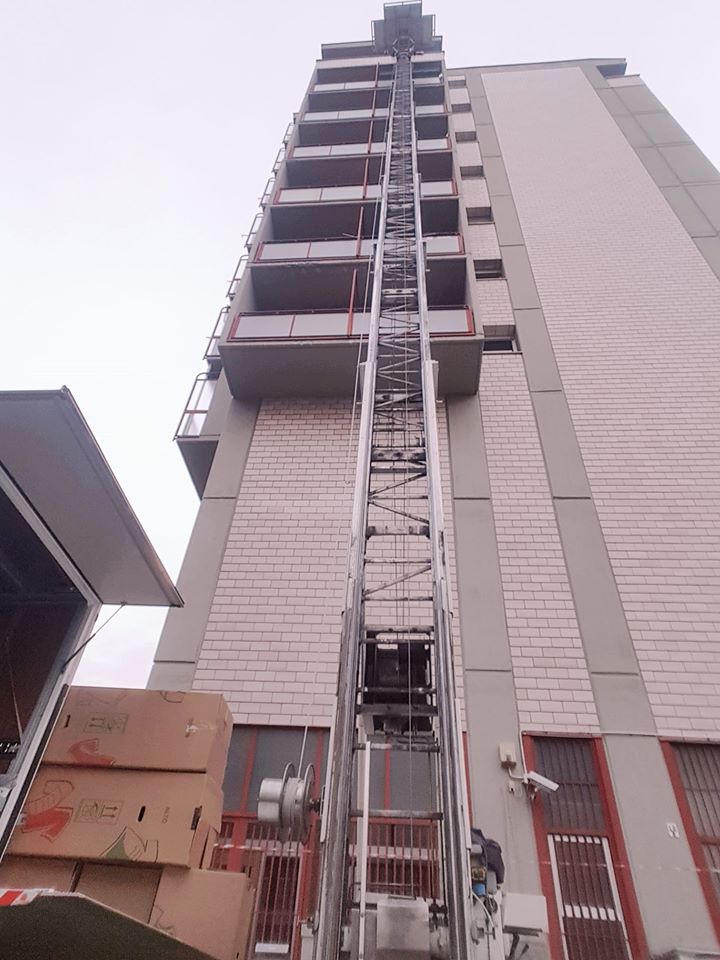 Edificio alto con montacarichi o ascensore a sviluppo verticale sulla facciata.
