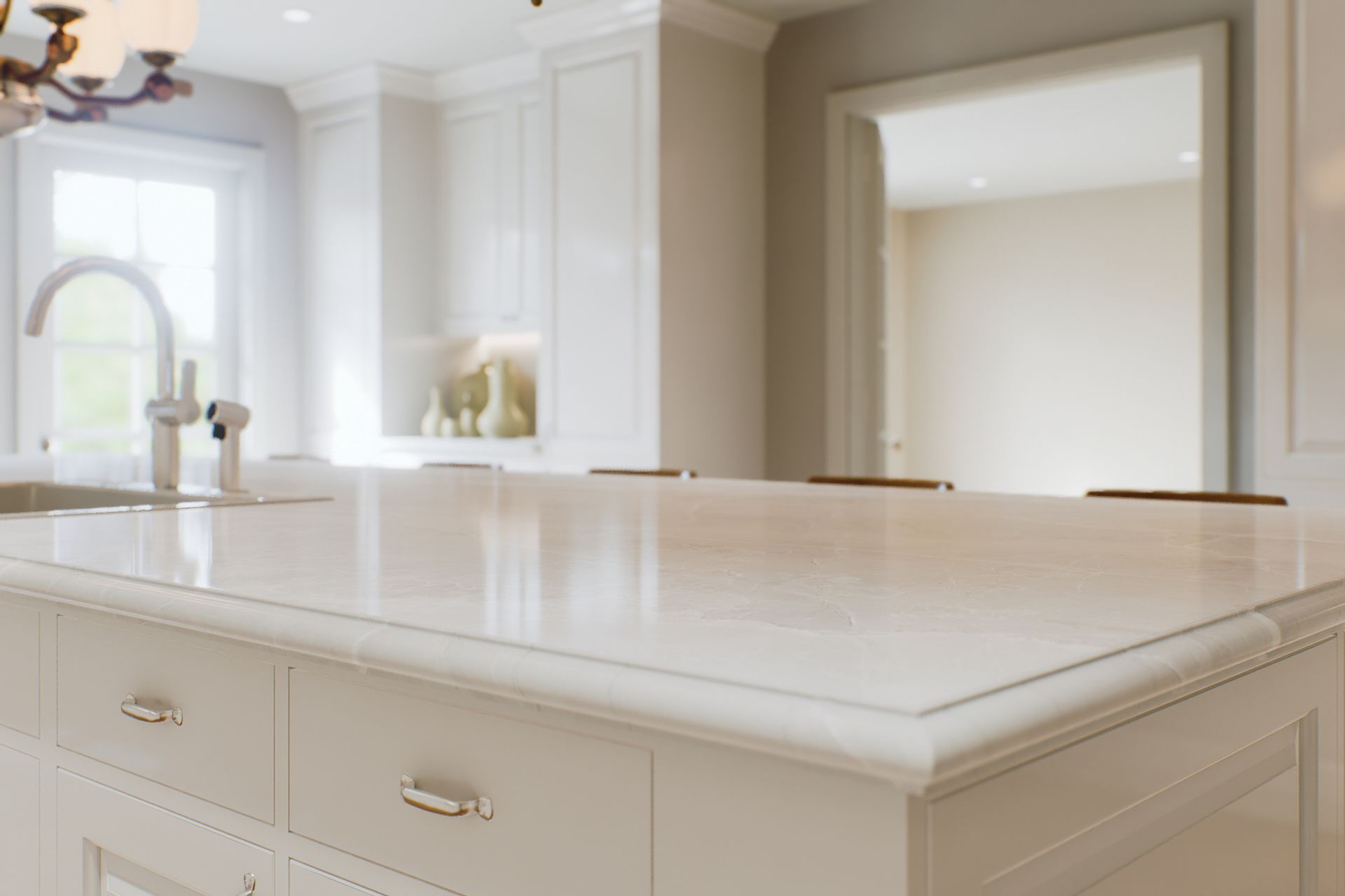 Bright white kitchen with a large marble island and ornate cabinetry, seen from across the room