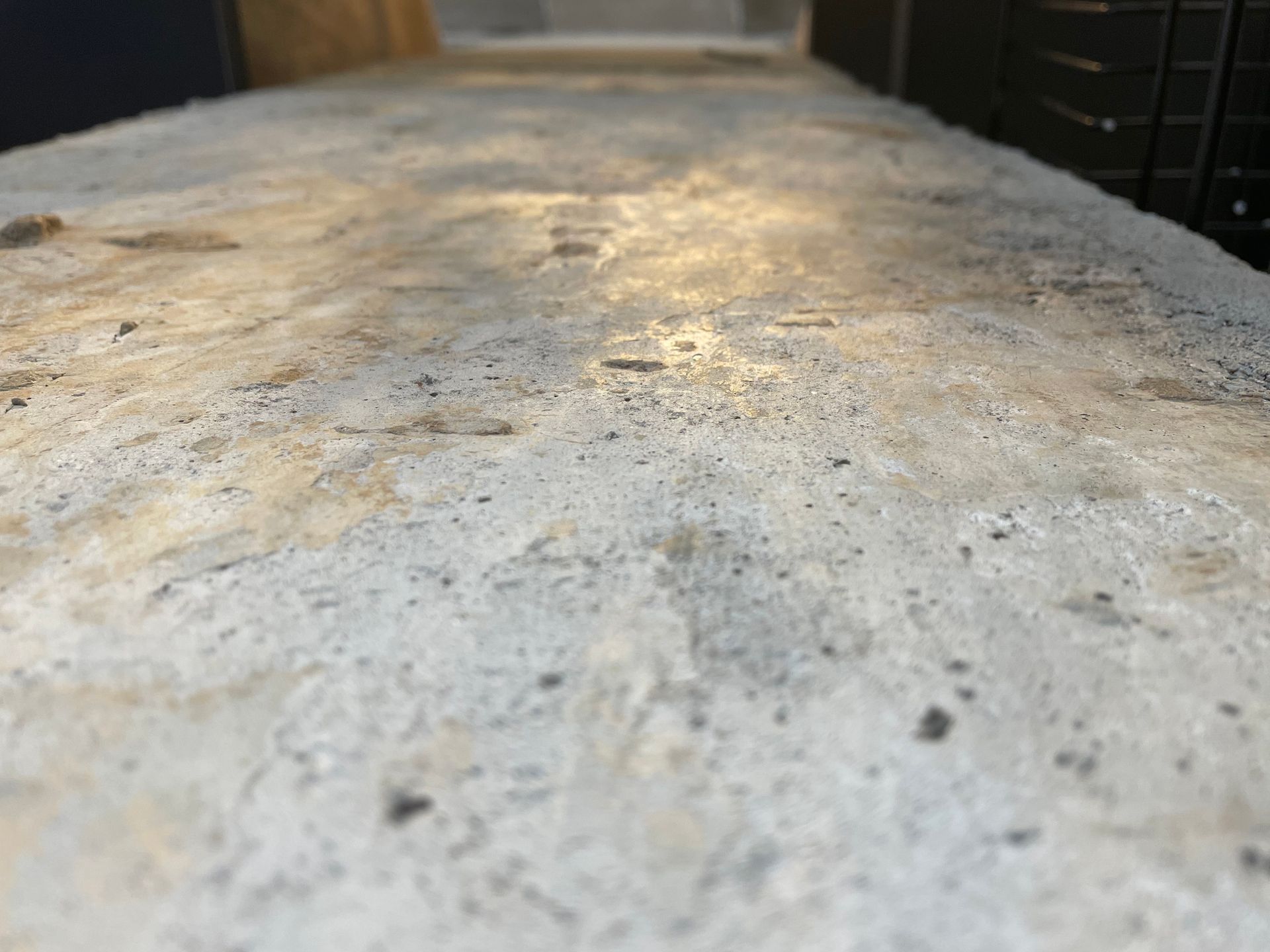Close-up view of a rough, light gray concrete surface.