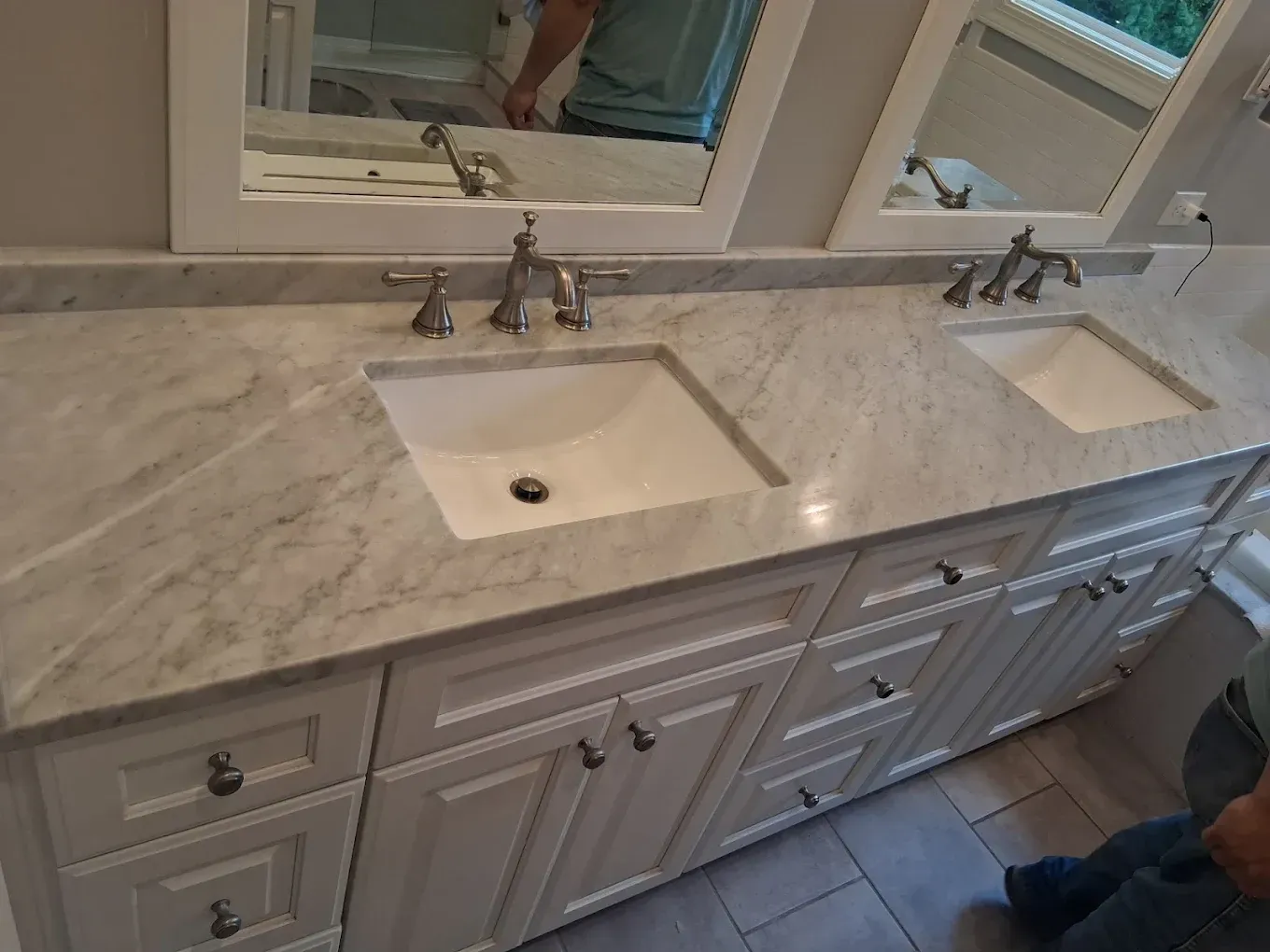 Light gray marble kitchen countertop with an integrated sink and dark cabinet below