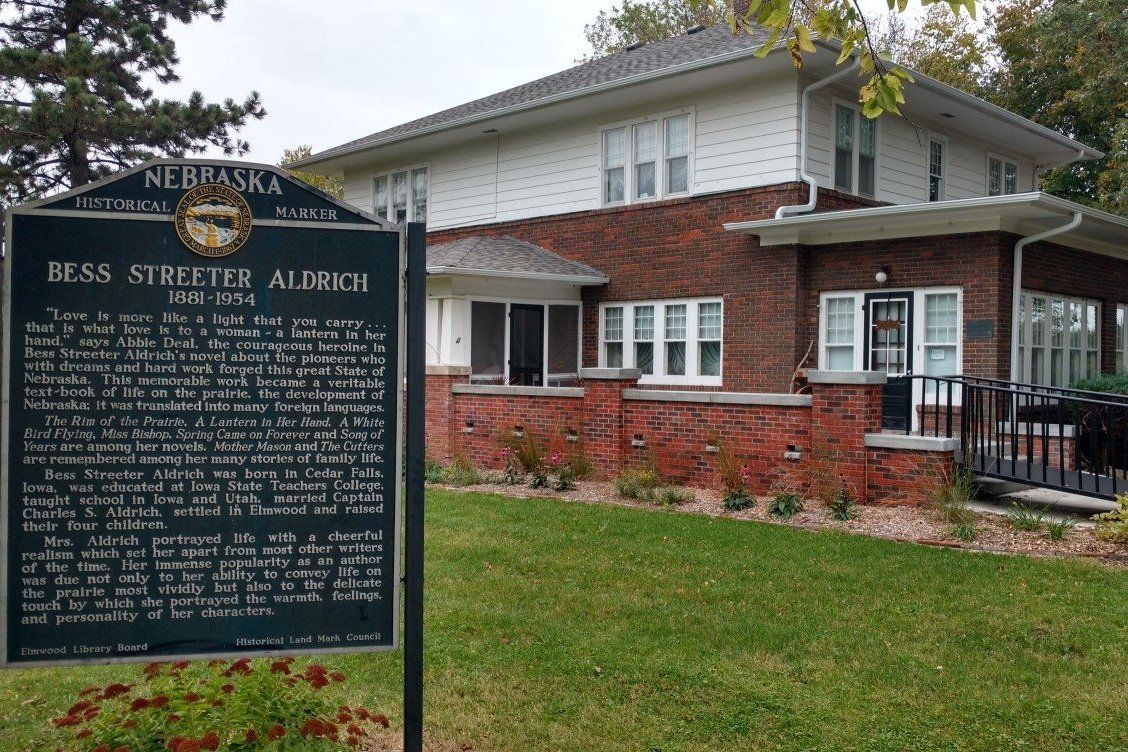A brick house with a historical marker in front of it