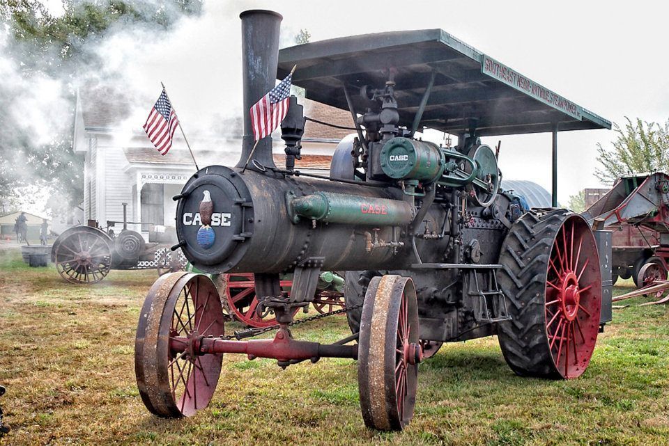 An old tractor with a steam engine on top of it.