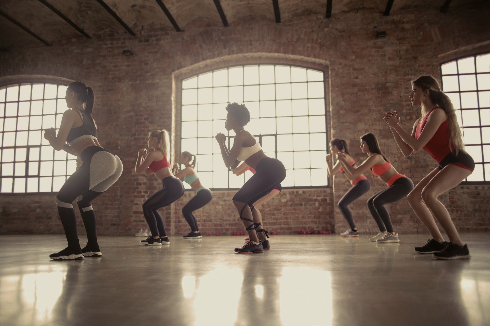 Un groupe de femmes sont accroupies dans une salle de sport.