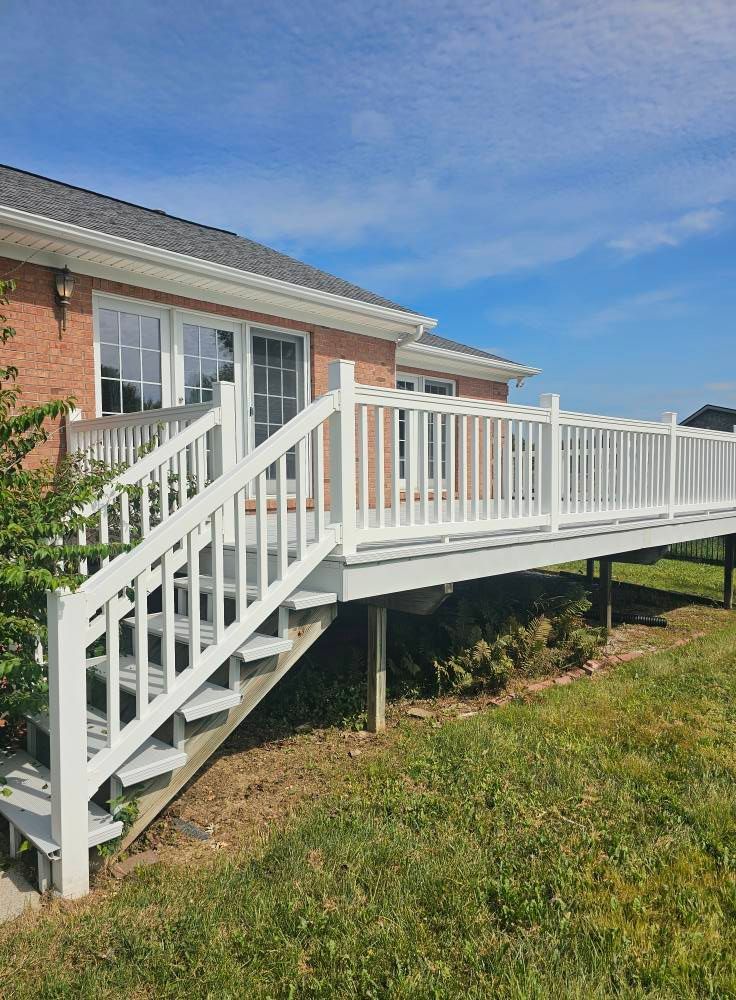White wheelchair ramp and stairs attached to a brick house under a blue sky