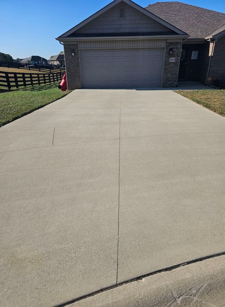 Driveway leading to a single-story house with a two-car garage on a sunny day