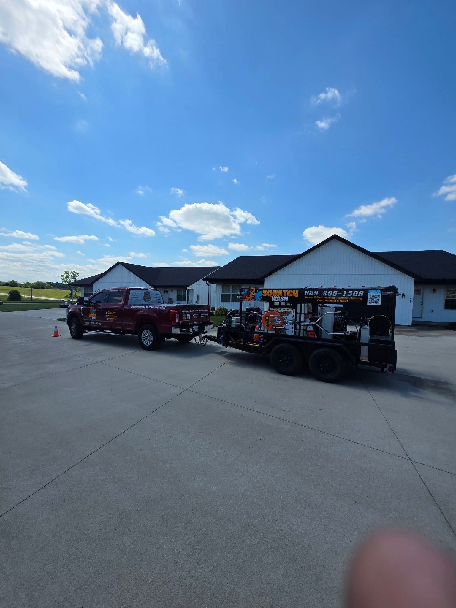 Two utility carts parked on a concrete lot beside a white building under a blue sky.