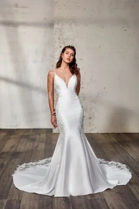 Woman in white wedding dress with plunging neckline, mermaid silhouette, and train.