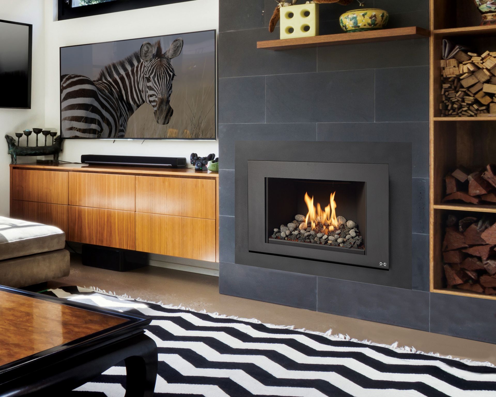 Custom Fireplace | Corvallis, OR | Schaefers Stove & Spa Modern living room with zebra artwork, black fireplace, wood cabinet, and black-and-white zigzag rug