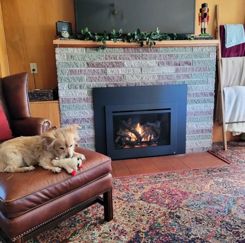 Cozy living room with a lit fireplace, patterned rug, and a small dog resting on a leather chair.