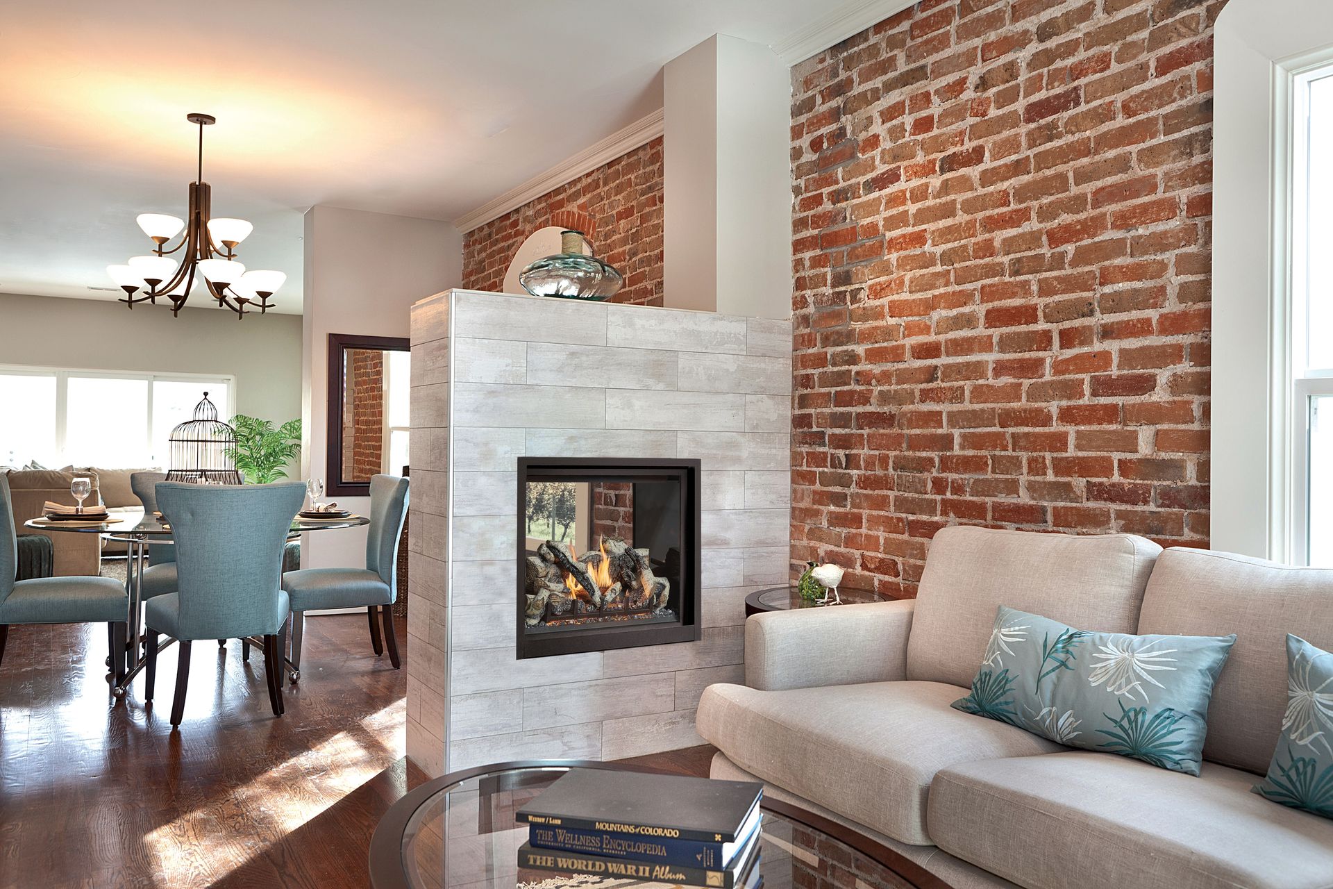 Couple on a Hot Tub | Corvallis, OR | Schaefers Stove & Spa Bright living room with brick accent wall, modern fireplace, beige sofa, and dining area beyond.