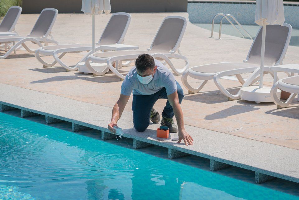 Man Inspecting Pool Water | Corvallis, OR | Schaefers Stove & Spa