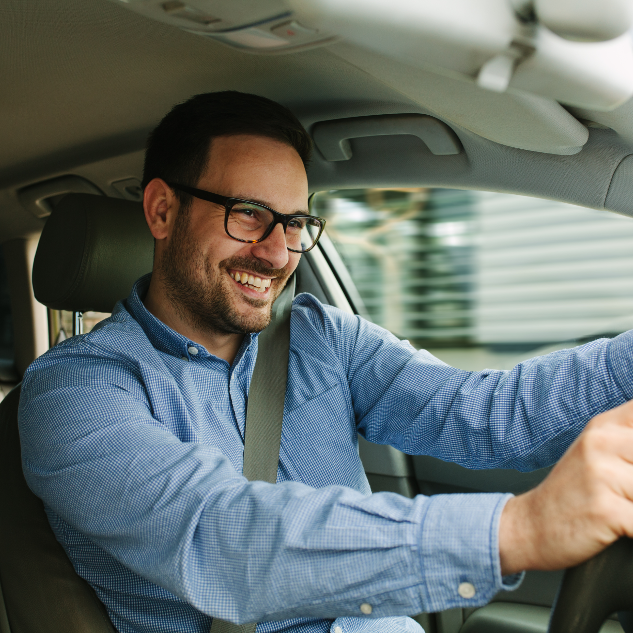 Man driving car with two children. Sunlight, smiles, seatbelts.
