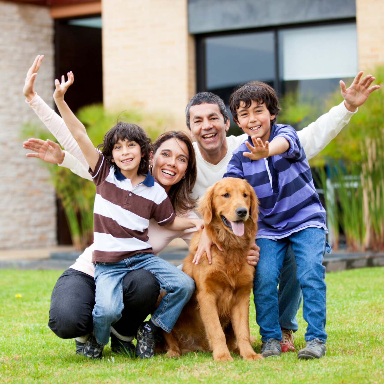 Family exiting a brick house. A child runs ahead while parents follow smiling.