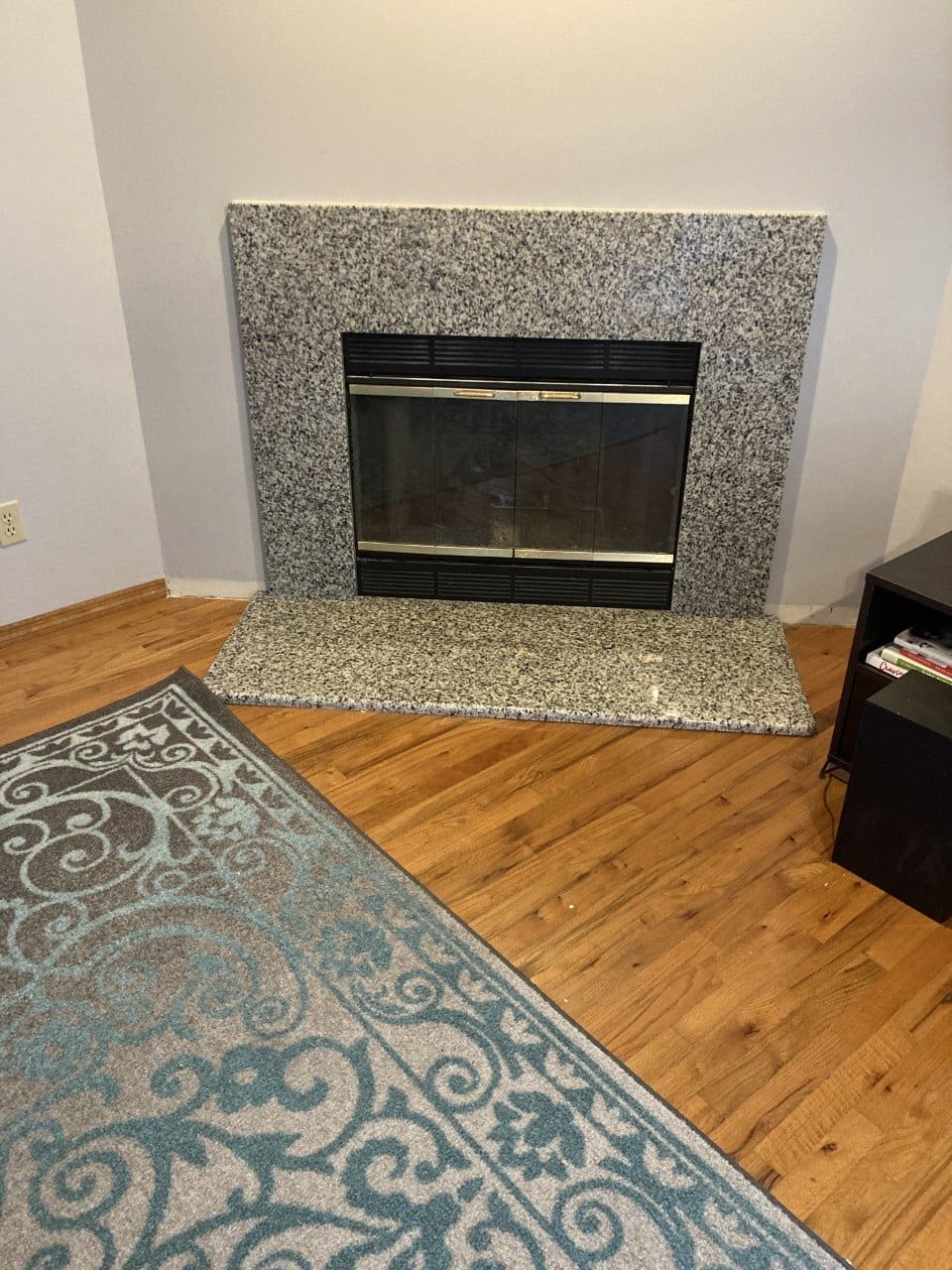 A living room with a fireplace and a rug - Luther Falls Kitchen & Bath - Champaign, IL