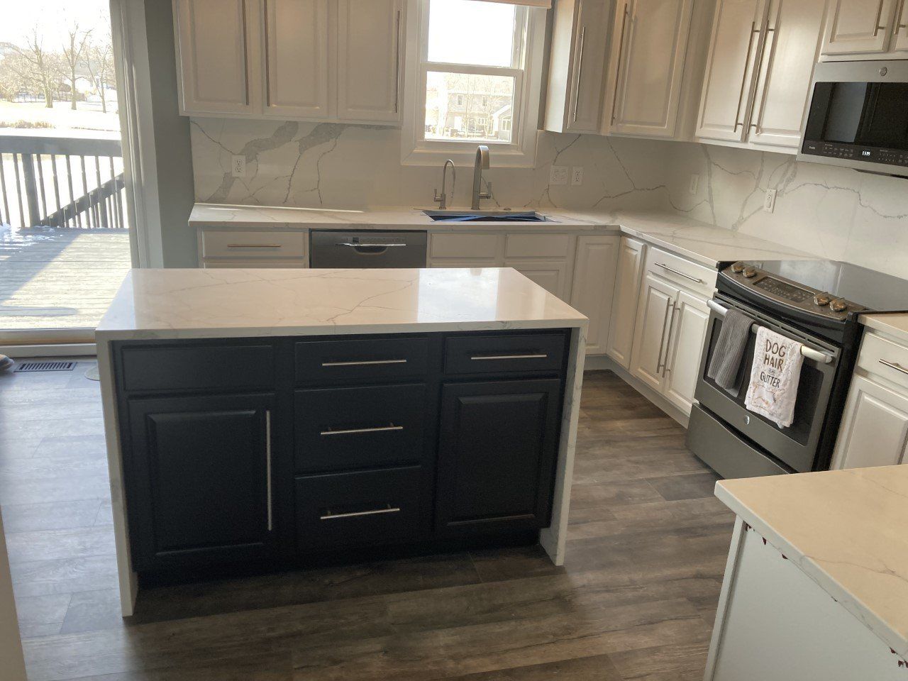 A kitchen with a large island in the middle - Luther Falls Kitchen & Bath - Champaign, IL