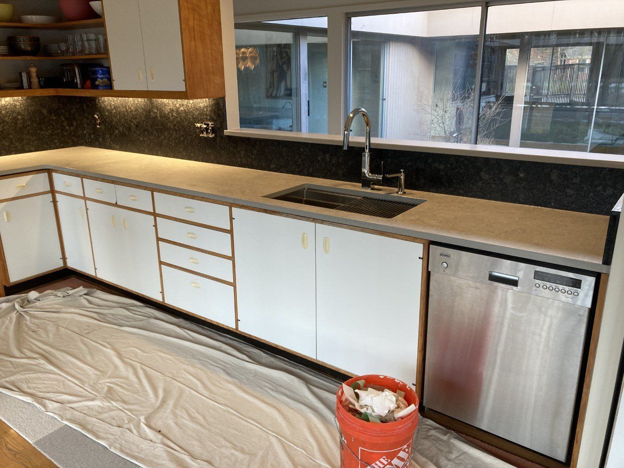 A kitchen with white cabinets and a stainless steel dishwasher - Luther Falls Kitchen & Bath - Champaign, IL