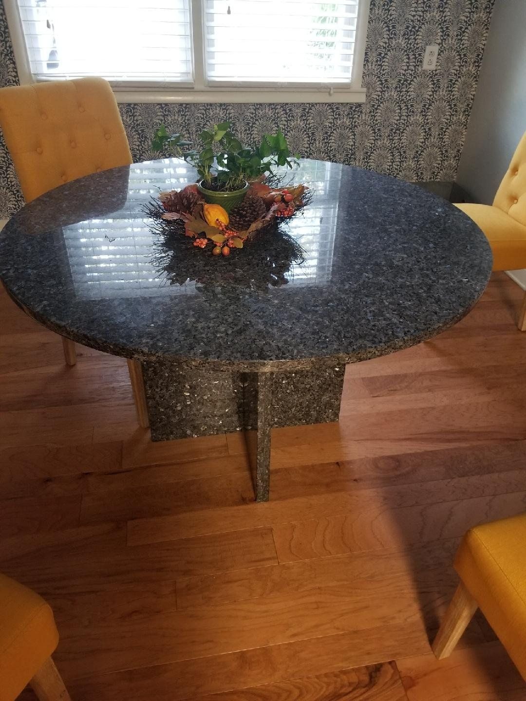 A round dining table with a vase of fruit on top of it - Luther Falls Kitchen & Bath - Champaign, IL