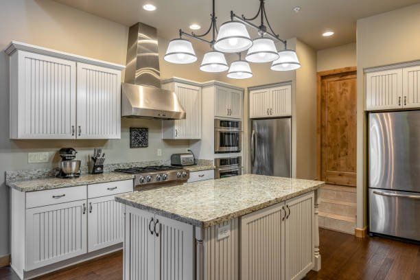 A kitchen with white cabinets , granite counter tops , stainless steel appliances and a large island - Luther Falls Kitchen & Bath - Champaign, IL