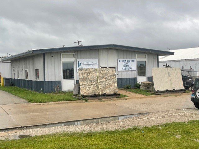 A large building with a lot of marble pieces in front of it- Luther Falls Kitchen & Bath - Champaign, IL