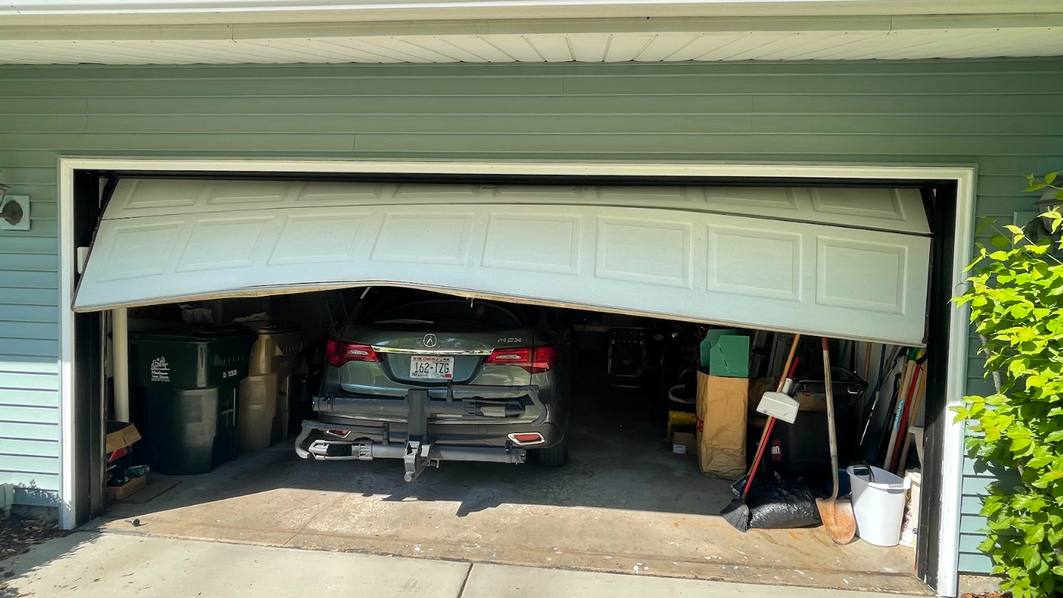 A car is parked in a garage with the door open.