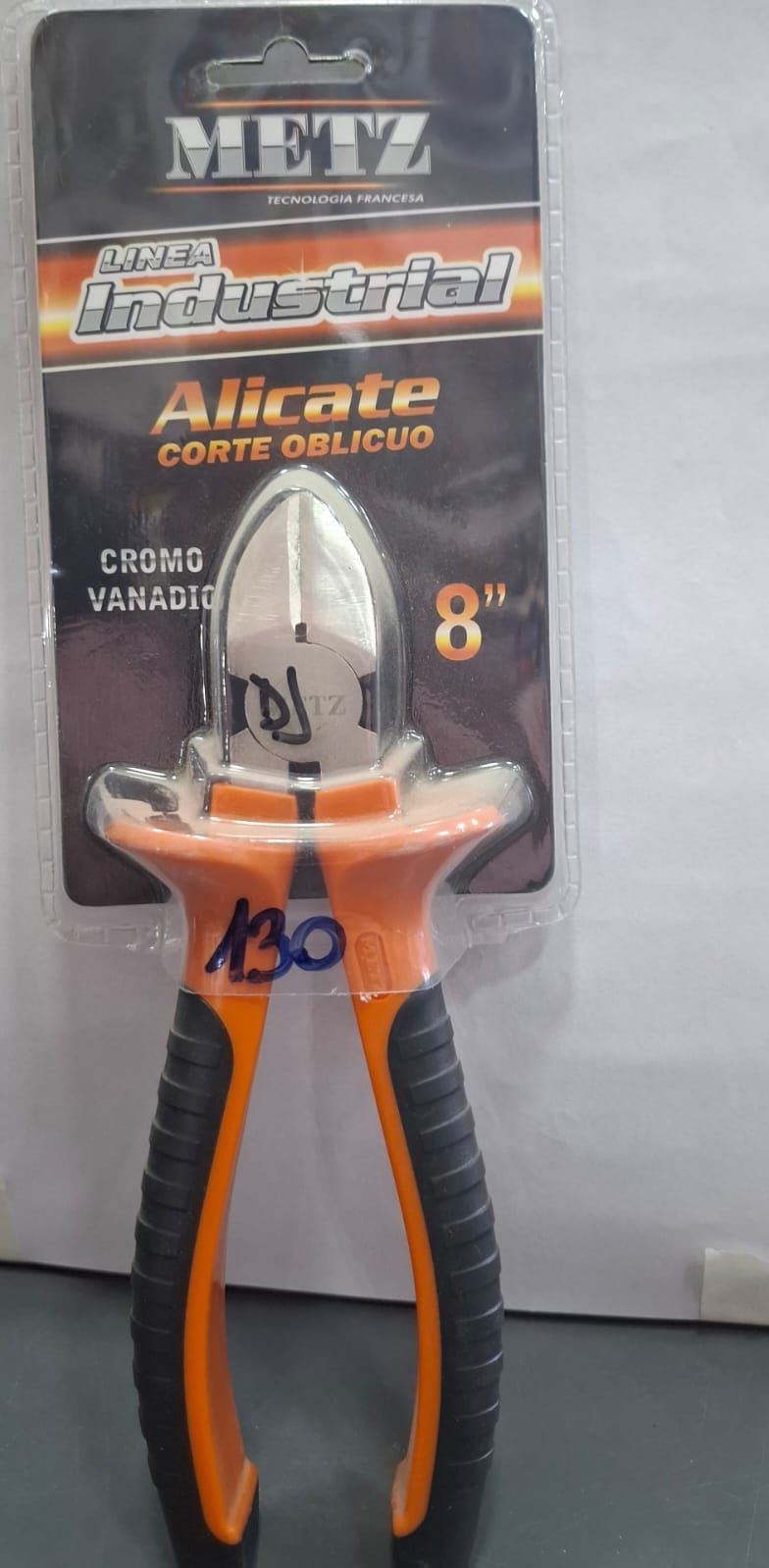 Alicates de color naranja y negro en embalaje para venta al por menor, con mordaza de corte metálica y tarjeta expositora colgante.