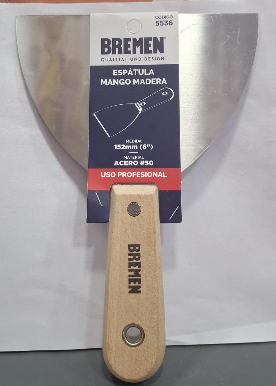 Espátula de Bremen con mango de madera y etiqueta del envase, mostrada sobre un fondo claro.