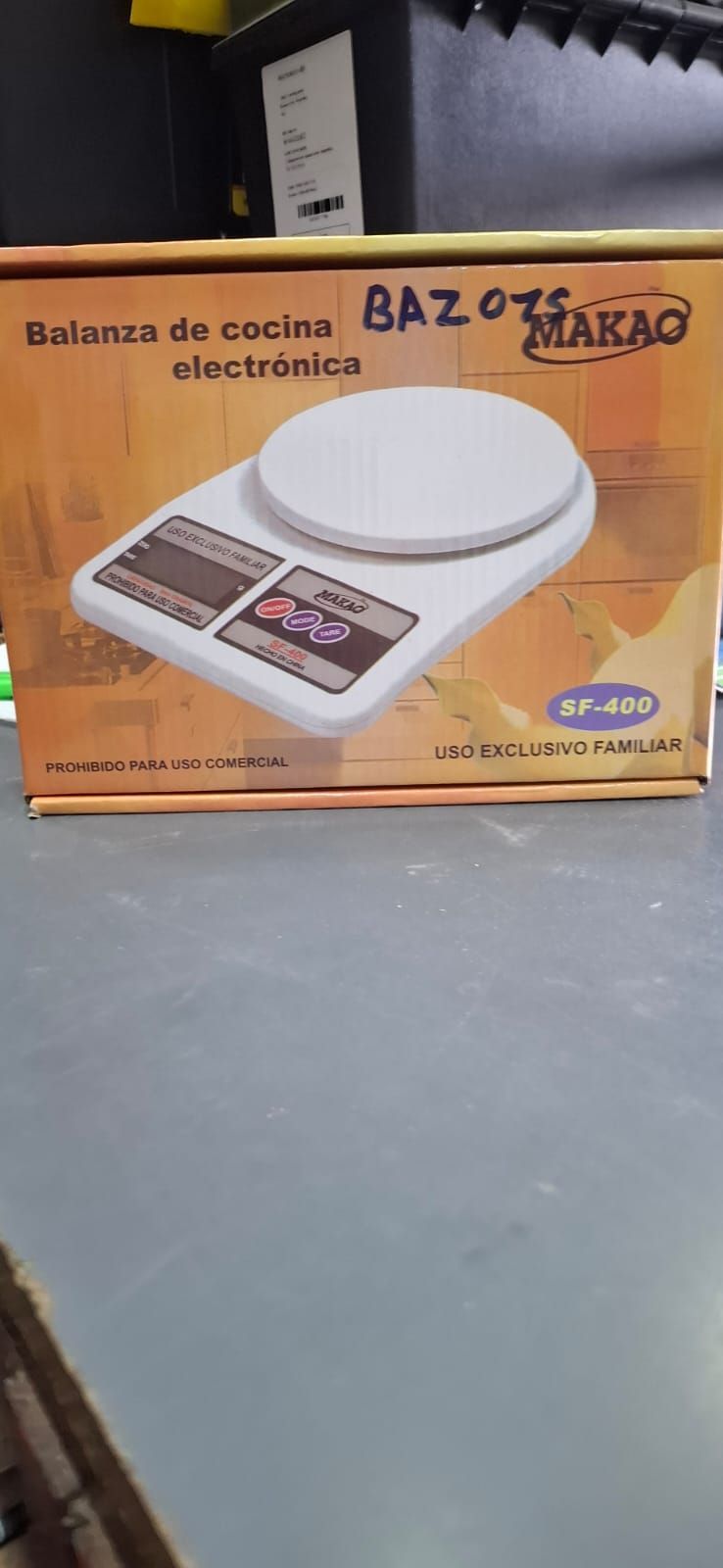 Caja naranja de una báscula de cocina digital con una escala blanca impresa en la parte frontal.