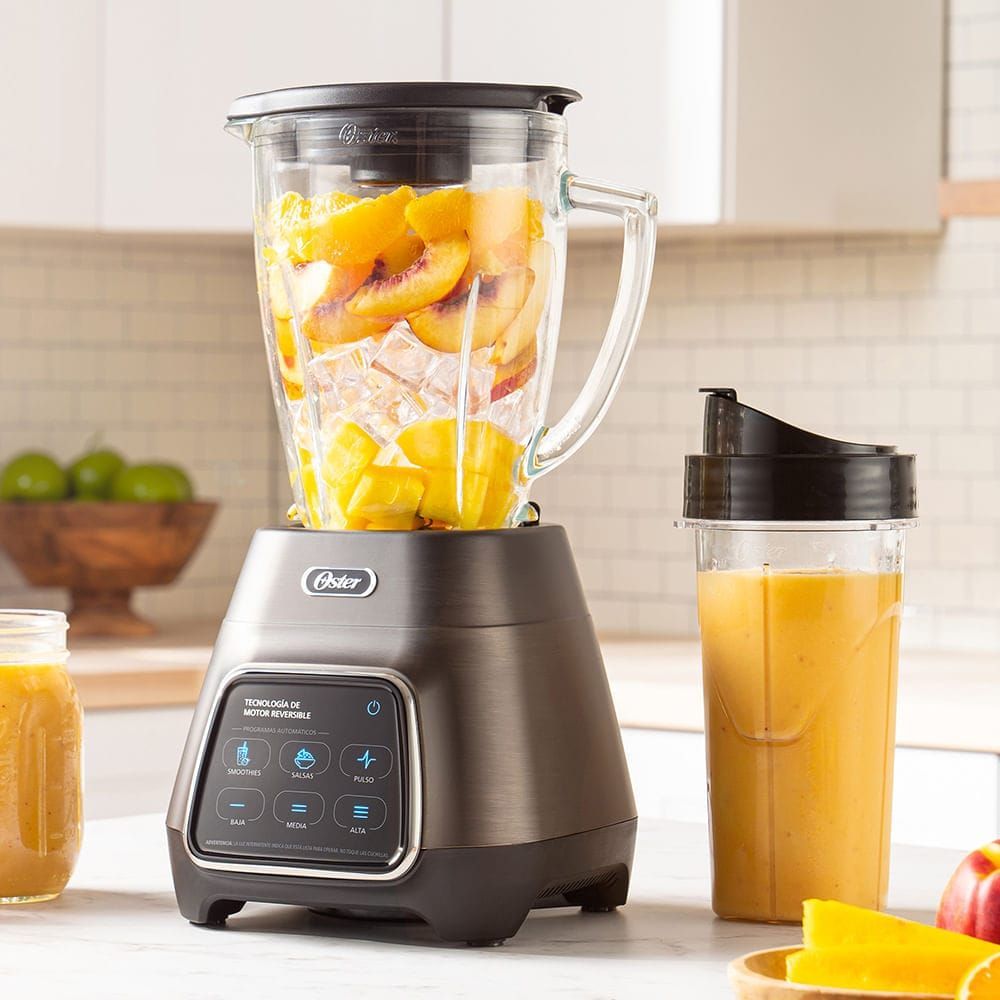 Licuadora de encimera con jarras para frutas y zumos en una cocina luminosa.