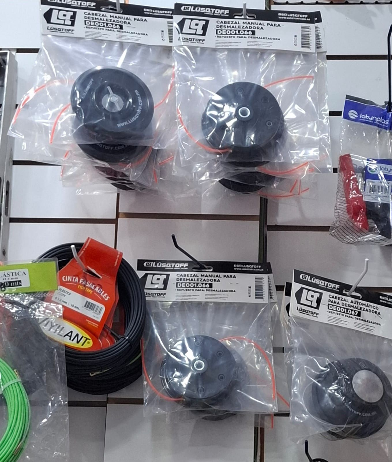 Surtido de cables y conectores enrollados en envases de plástico, expuestos en un estante de la tienda.