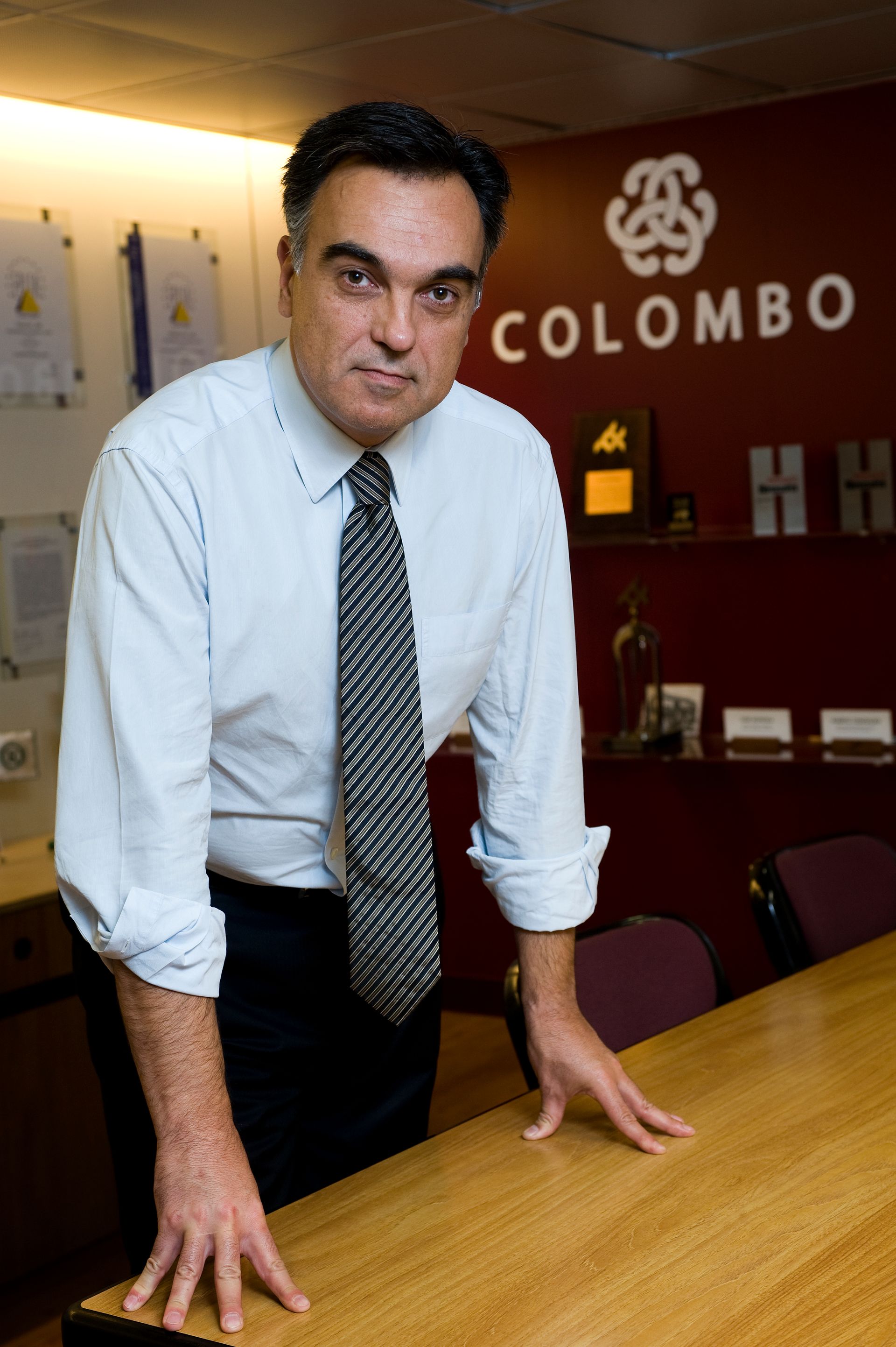 Retrato editorial de dirigente em contexto empresarial, foco em discrição e profissionalismo