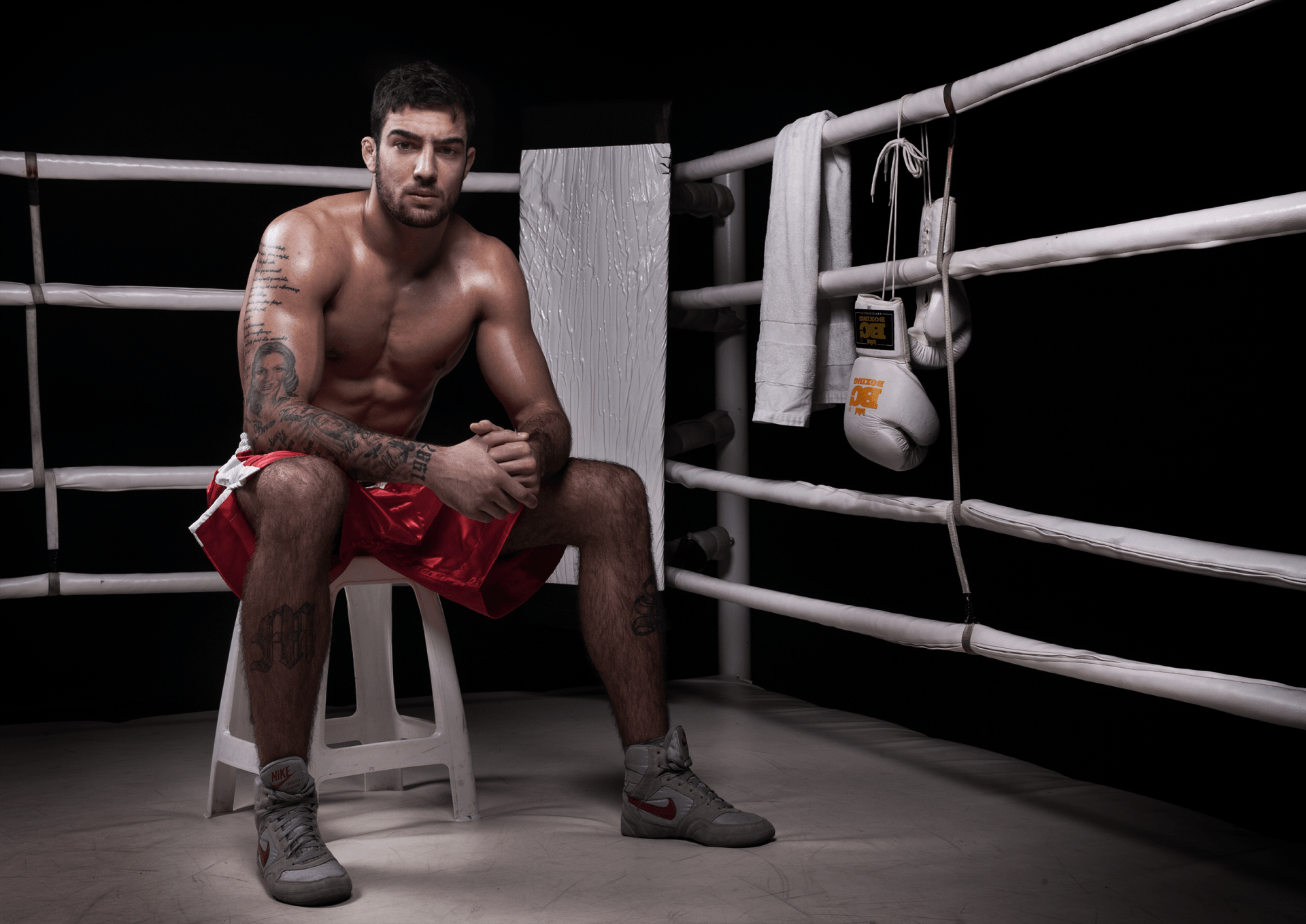 Fotografia pugilista em ginásio, iluminação enfatizando musculatura