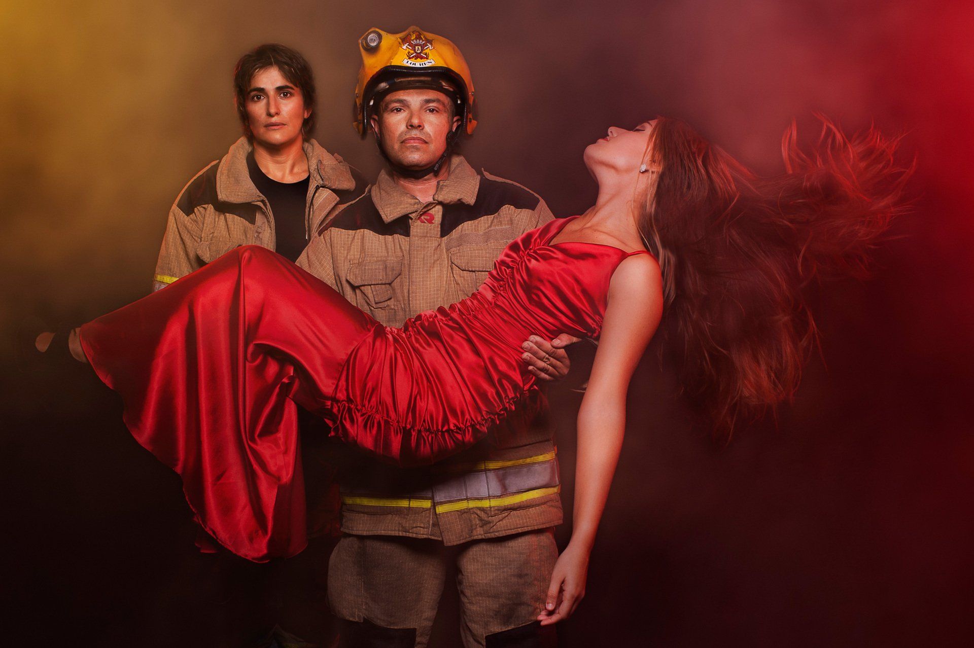 Fotografia de bombeiros em cenário de estúdio simulando salvamento para calendário solidário