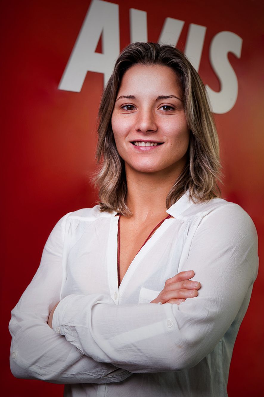 Retrato de Telma Monteiro em contexto institucional, com expressão simpática e postura casual
