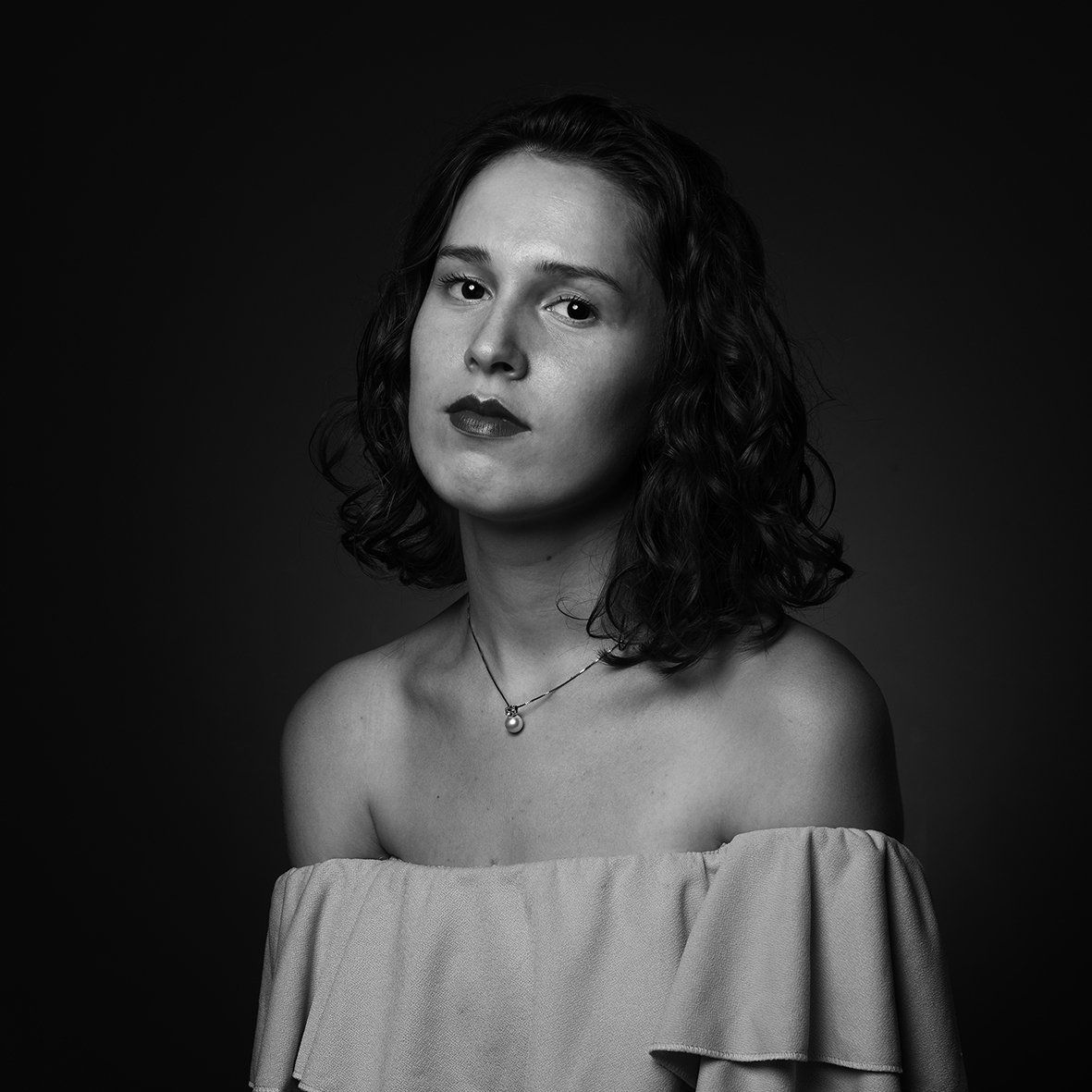 Retrato em estúdio de pessoa comum com iluminação dramática e fundo neutro