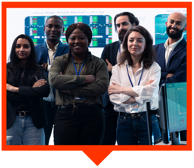 A diverse group of six professionals standing with arms crossed in a modern office with stock market screens in the back.
