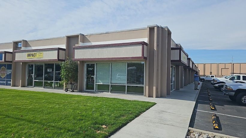 A building with a lot of windows and a lot of grass in front of it.