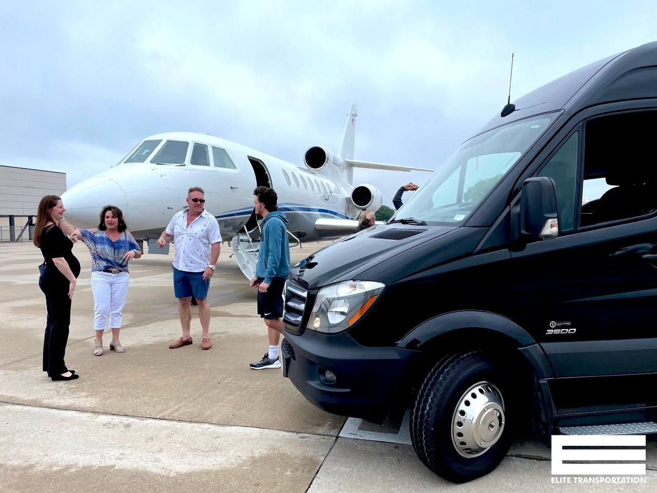 Black van and plane with people near at an airport.