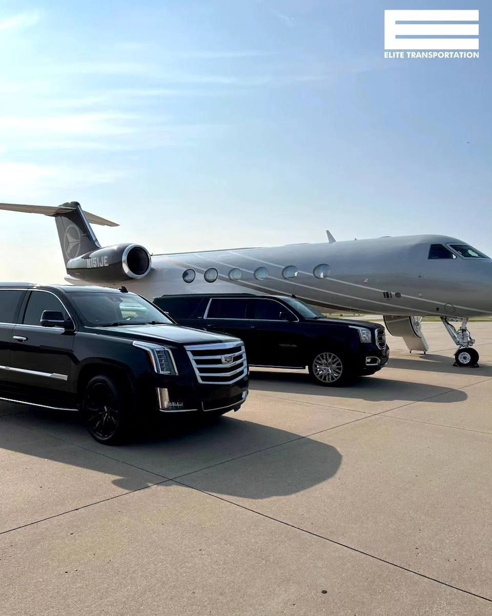 Two black SUVs in front of a private jet on a tarmac under a sunny sky.