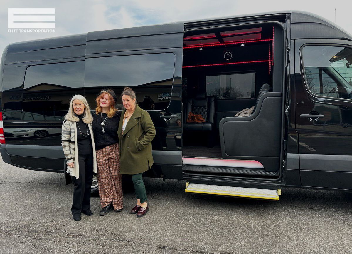 Three people stand by an open-door black van. The interior has red lighting.