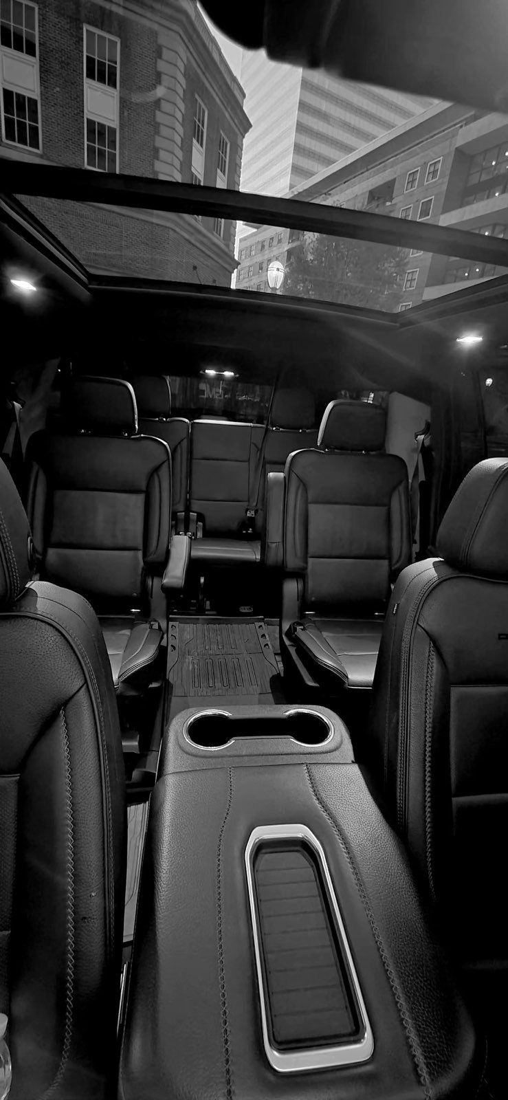 Empty luxury car interior with black leather seats and a panoramic sunroof