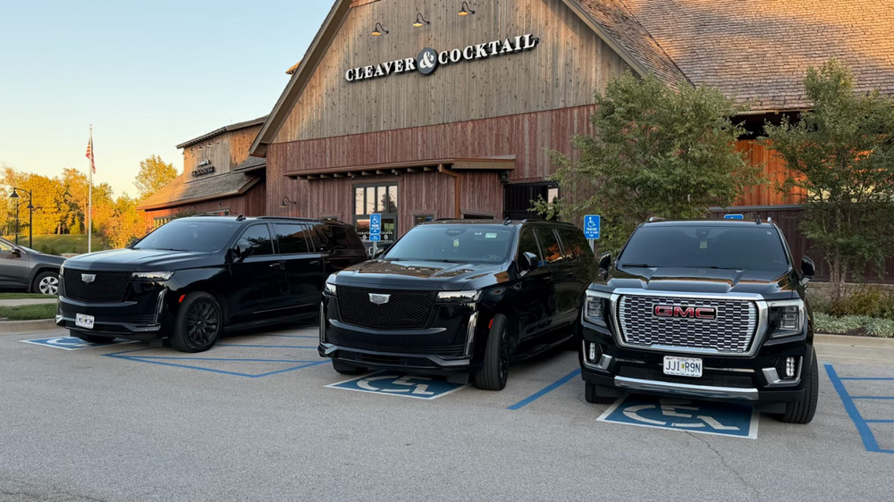 Three black SUVs parked in front of 