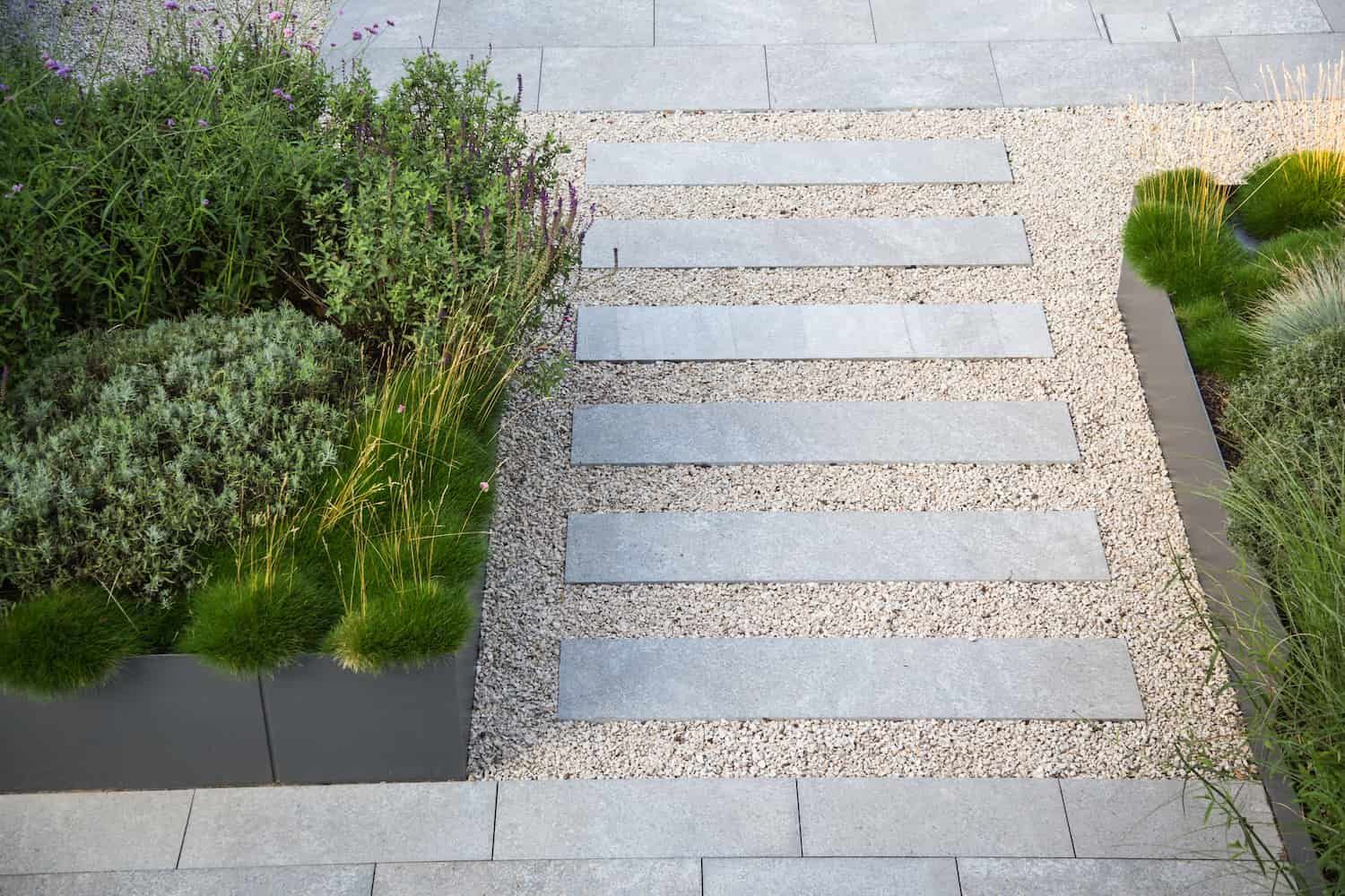 A Stone Walkway Surrounded by Gravel and Plants in a Garden — The Brick Paving Centre in Winnellie, NT