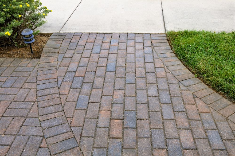 Curved brick walkway connecting to a concrete path for Paving Darwin projects.