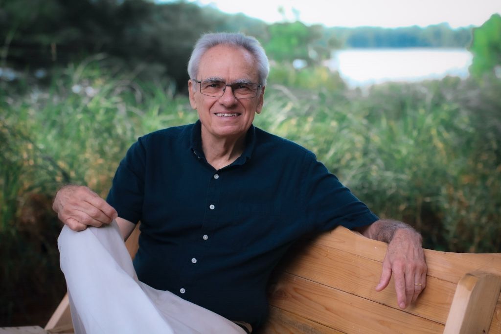 Richard Paterson sitting on a bench by a lake