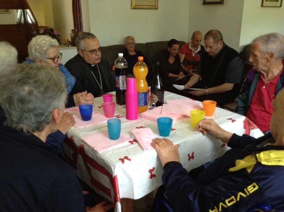 People seated around a table with colorful cups and bottles in a casual indoor gathering