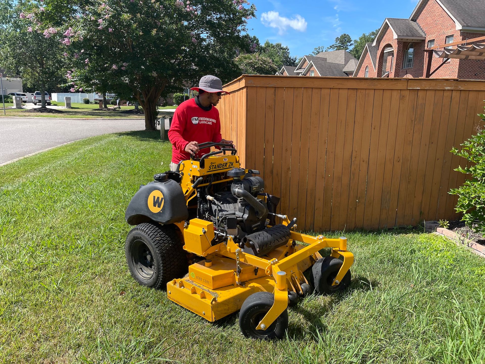 A man is riding a yellow lawn mower on a lush green lawn.