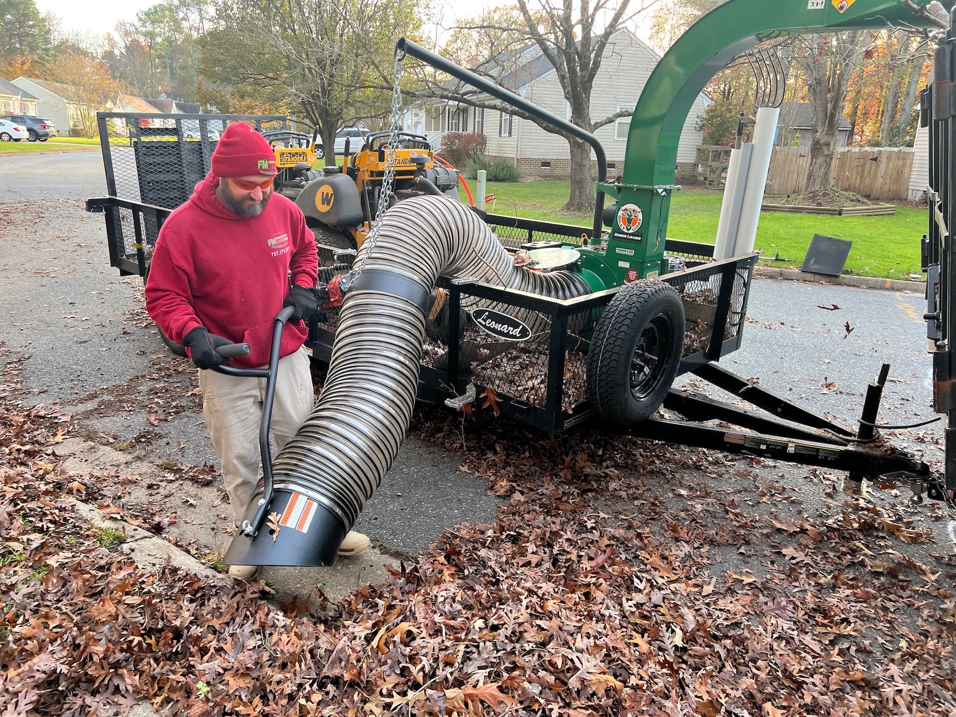 A man is standing next to a trailer with a hose attached to it.