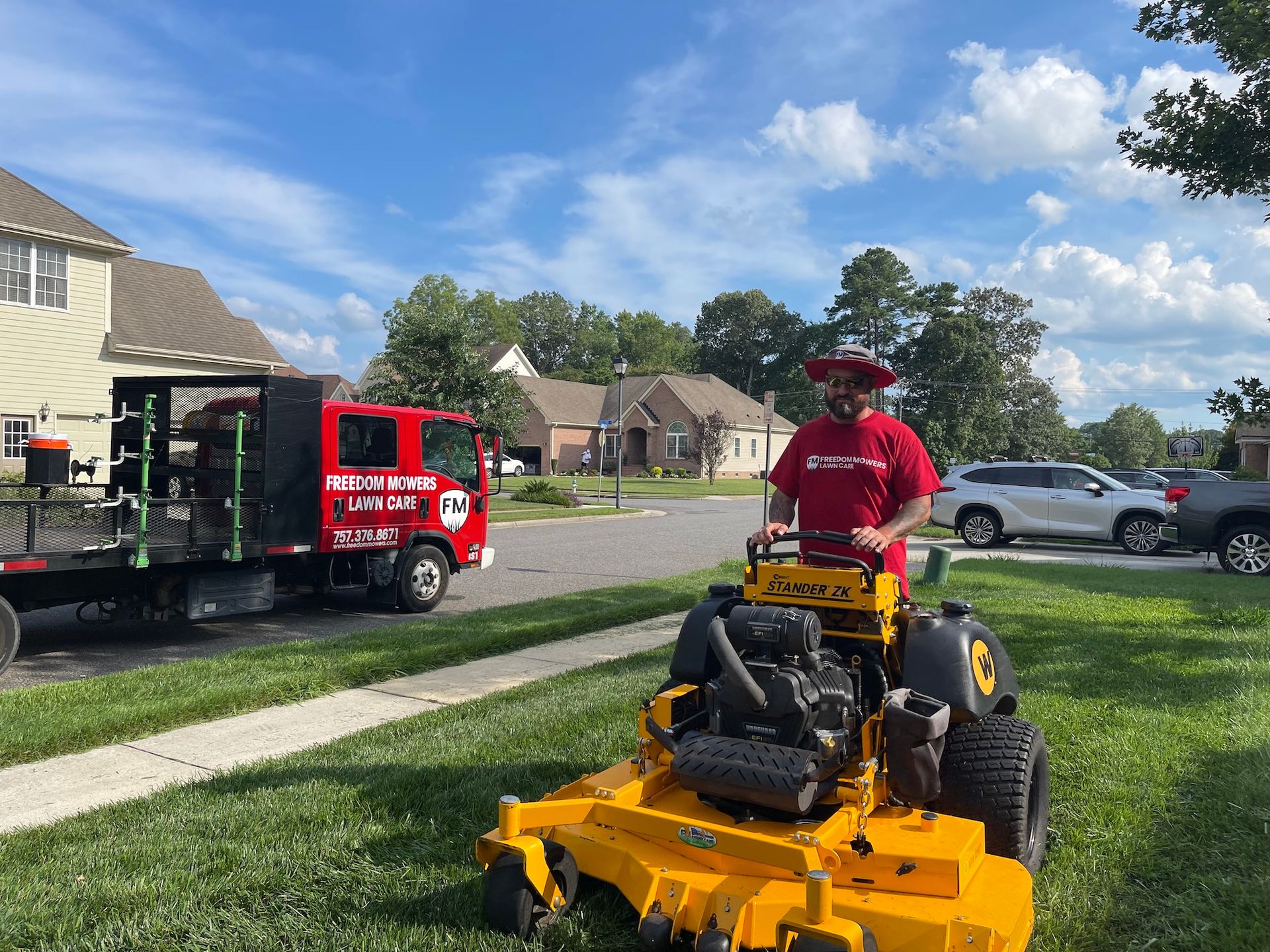 A man is riding a yellow lawn mower on a lush green lawn.
