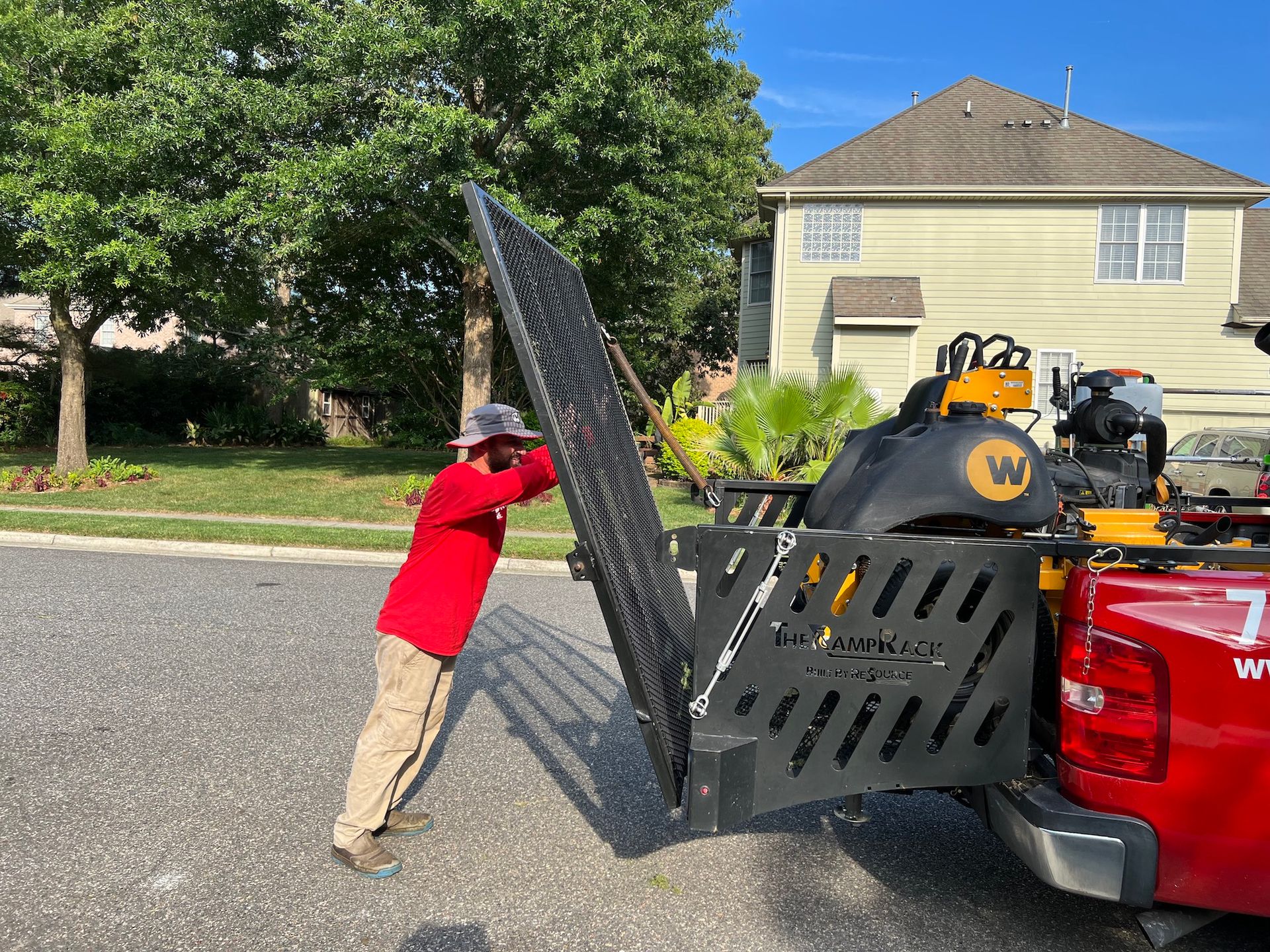 A man is pushing a fence into the back of a truck.